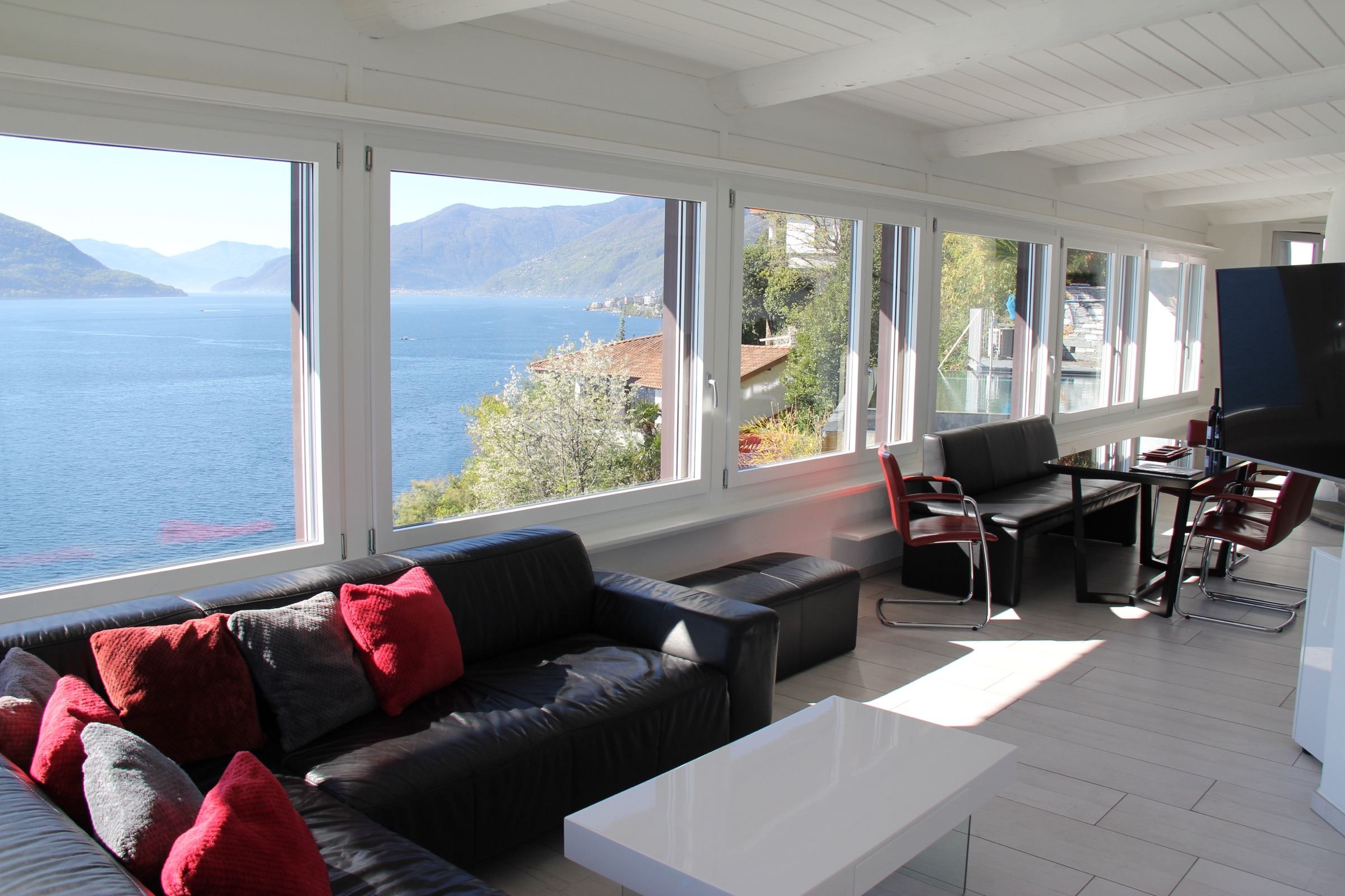 Wohnzimmer der Casa Rondine mit Panoramafenstern und Blick auf den Lago Maggiore